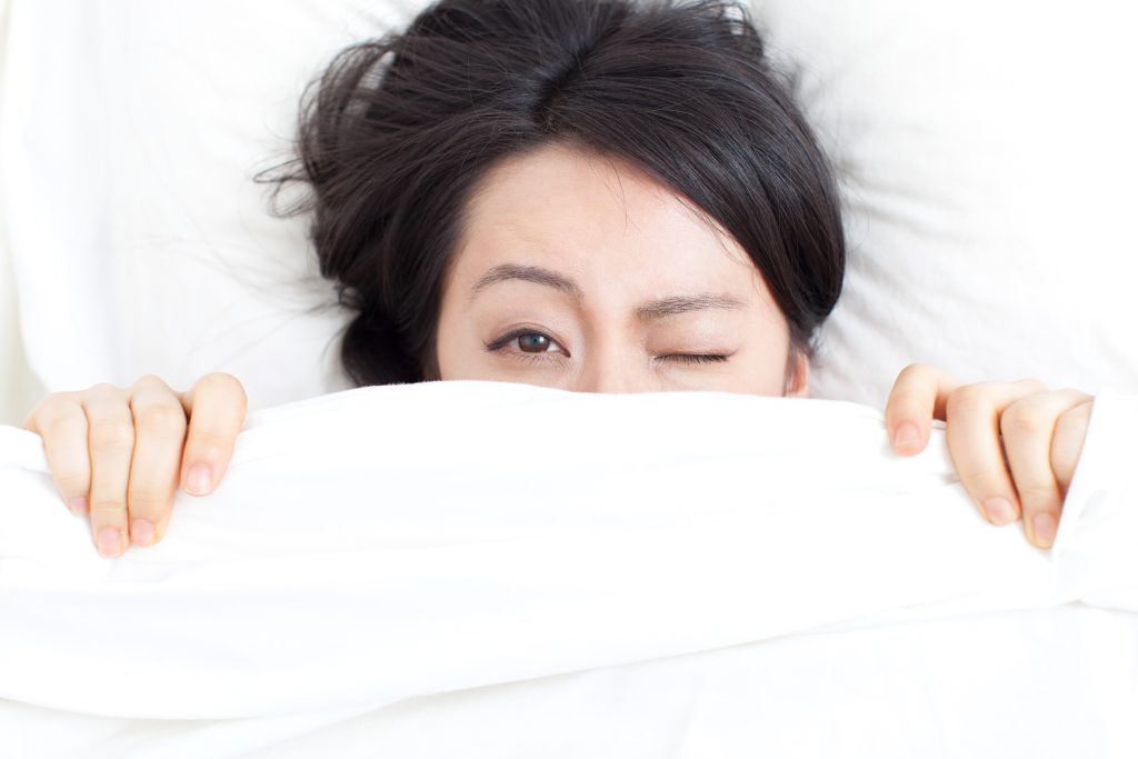 Frau liegt verschlafen im Bett Kreislauf